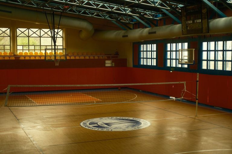 Legados distintos do vôlei: Fabi Alvim, Alison e Ary Graça são indicados ao Hall da Fama Quadra esportiva coberta com rede de vôlei e uma cesta de basquete ao fundo